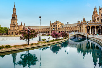 Fototapeta na wymiar The canal in the Plaza de Espana in Seville, Spain sweeps around towards the north tower in the early morning in summertime