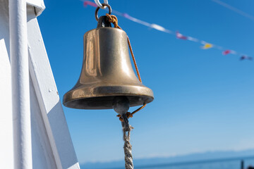 Ship's bell against the blue sky, close up.