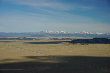 Multiple fourteeners on the horizon of planes in Colorado. Balloon ride shows vast landscapes and hazy view of the rocky mountains