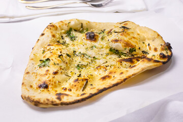 A view of a serving of garlic naan bread, in a restaurant or kitchen setting.