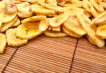 Banana chips on white background bamboo mat