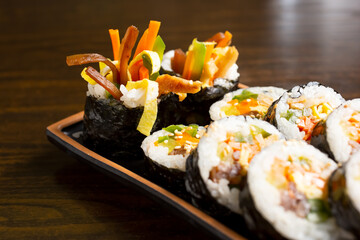 A closeup view of a plate of kimbap roll, in a restaurant or kitchen setting.