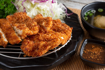 A view of a plate of chicken katsu, in a restaurant or kitchen setting.