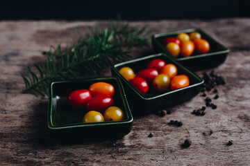 Cherry tomato with herbs on a wooden textured table