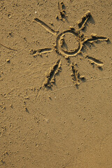 The sun drawn by fingers on the beach sand.