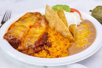 A view of a plate of enchiladas, in a restaurant or kitchen setting.
