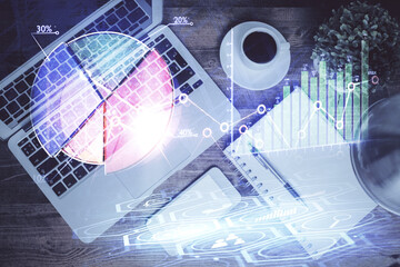 Financial market graph and top view computer on the desktop background. Double exposure. Investment concept.