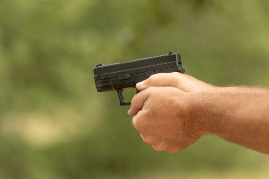 Man's hand holding a gun 