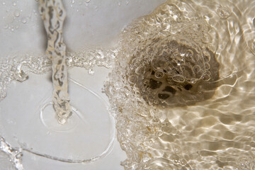 Dirty light orange flowing water from the tap. Water pollution problem