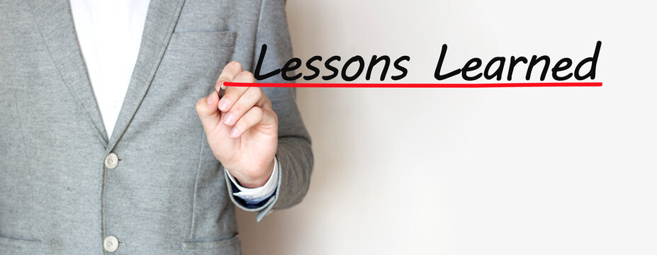 Businessman Writing A Text LESSONS LEARNED With Marker, Business Concept