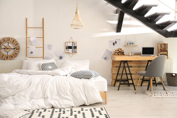 Elegant interior of bedroom with workplace under stairs