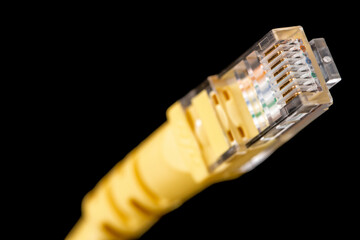 Macro image of yellow network plug over black background. Fiber optic.
