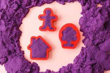 kinetic sand in shape of tree and man.