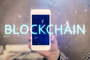 Double exposure of man's hands holding and using a phone and crypto currency blockchain theme drawing.