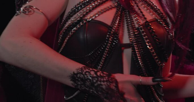 Sexy woman in black leather clothes, with long nails is touching her body, 4k