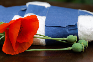 flowers and opium poppy heads next to packages of heroin, soft focus, toning
