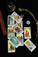 Fototapeta na wymiar Tarot cards, candle, incense, sage, cauldron and essence.