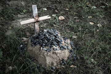 the grave of the family's beloved pet, a sand mound and a hand-made wooden cross