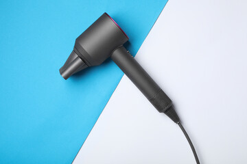 Hair dryer on color background, top view. Professional hairdresser tool