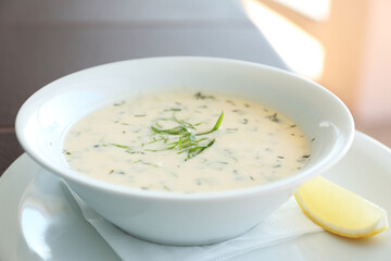 Delicious soup served with lemon slice, closeup