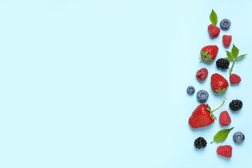 Different fresh berries on light blue background, flat lay. Space for text