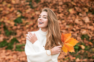 Autumn beauty. Woman fashion wodel with fall maple leaf outdoors.