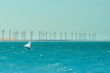 Raft in the sea and in the background wind turbines in Aracati, near Fortaleza, Ceara, Brazil on...