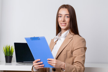 Happy beautiful business woman with clipboard in the office.
