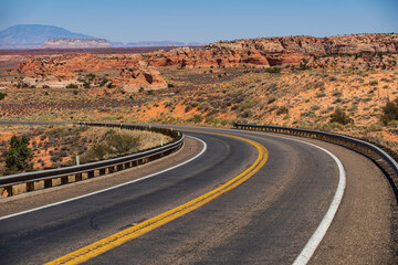 Fototapeta na wymiar Desert highway at sunset, travel concept, USA. Asphalt road and canyon background.