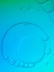 Abstract oil droplets on water with blue colour background.