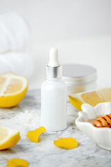 Skin care natural products ingredients for scrub body mask: honey, lemon juice, salt sugar, glass bottle with dropper on marble plate, handmade wellness set, self-care-focused concept