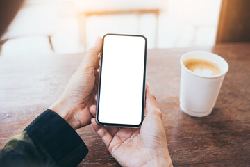 cell phone mockup image blank white screen.woman hand holding texting using mobile on desk at coffee shop.background empty space for advertise.work people contact marketing business,technology