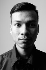 Portrait of young Asian businessman in black and white