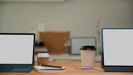 Fototapeta premium Meeting table with two digital tablets, paper cup and stationery in meeting room, clipping path.