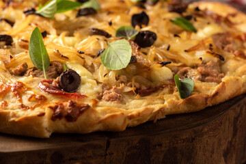 homemade rustic pizza with mozzarella cheese, mushrooms, olives on wooden table