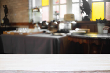 Empty wooden desk space and blurry background of cafe or Restaurant for product display montage.