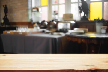 Empty wooden desk space and blurry background of cafe or Restaurant for product display montage.
