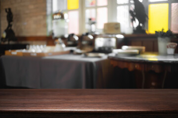 Empty wooden desk space and blurry background of cafe or Restaurant for product display montage.
