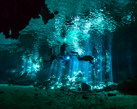 Team Of Cave Divers Descend Into A Underwater Cave System In Mexico.