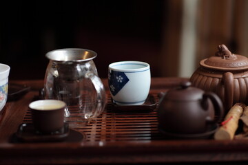 View of Traditional Chinese style tea set with Purple Clay Pots, tea cups and tea tools in a solid hardwood tea tray on table
