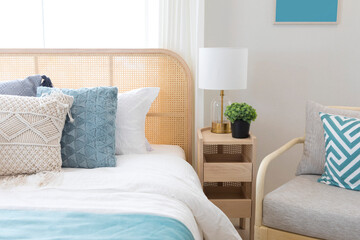 Cozy blue bedroom with modern interior, ethnic decor, comfortable bed, lamp over bedside table.