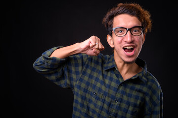 Portrait of happy young Asian hipster man with curly hair