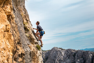 Rock climber on the background of mountains and sea.