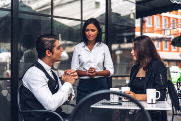 Group of cheerful young friend discussing meeting and talk enjoying their time drinking coffee together.Mixed race people sitting at cafe table and restaurant