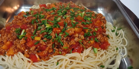 Pork spaghetti with chicken fillet on a white plate, long, thin, stiff pasta is a staple in traditional Italian cuisine. It is made from milled wheat with water, perhaps some mixed with flour, vitamin