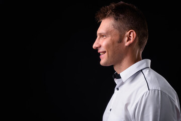 Obraz premium Portrait of happy businessman against black background
