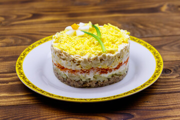 Traditional russian layered salad Mimosa with spring decoration Daffodil. Decoration is made of egg, green onion and carrot