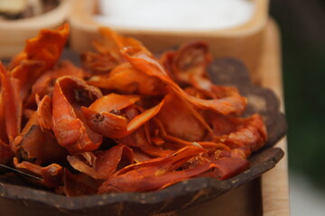 Orange mace in coconut shell bowl and blur background.