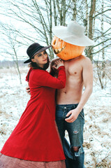 Halloween Scarecrow with a pumpkin on his head and a witch love each other