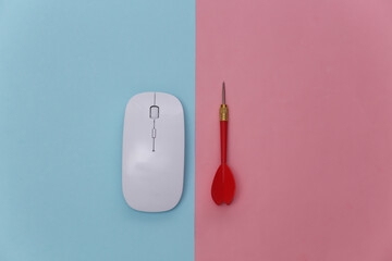 Pc mouse and dart on pink blue background. Top view